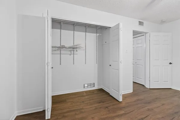 a view of an empty room with wooden floor