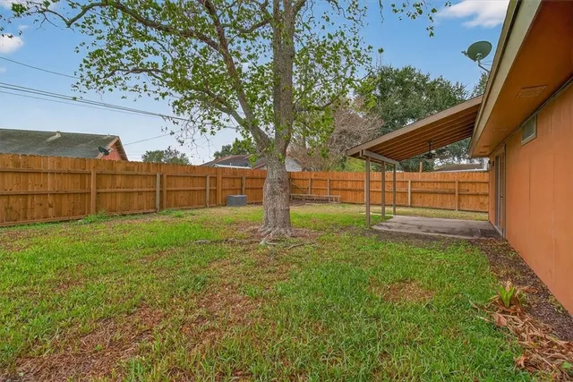 a view of backyard with wooden fence