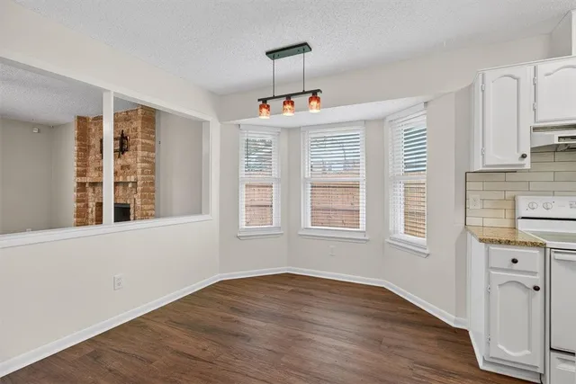 an entryway with wooden floor and cabinets