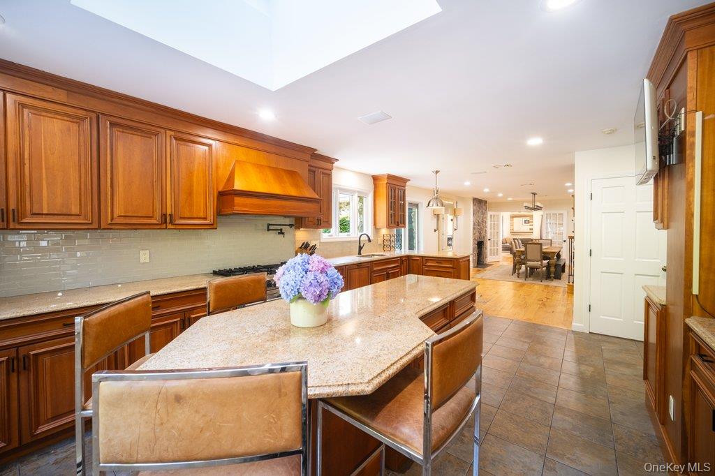 237 Mineral Springs Road Highland Mills, NY 10930 - Photo 15 of 32 Kitchen featuring brown cabinetry, decorative backsplash, a breakfast bar, light stone counters, and recessed lighting