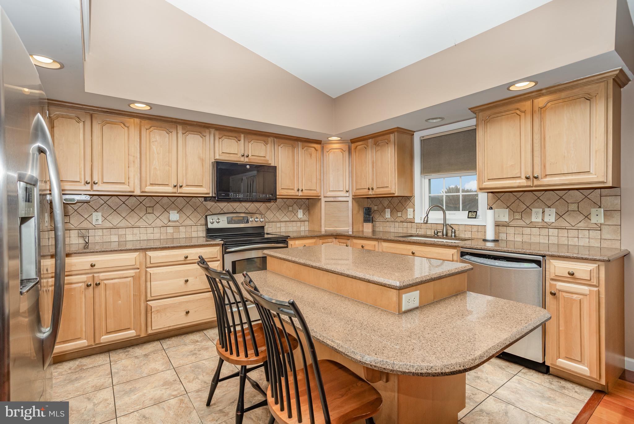 714 Heather Ridge Manheim, PA 17545 - Photo 12 of 33 a kitchen with stainless steel appliances granite countertop a stove a sink dishwasher a microwave oven with a dining table and chairs