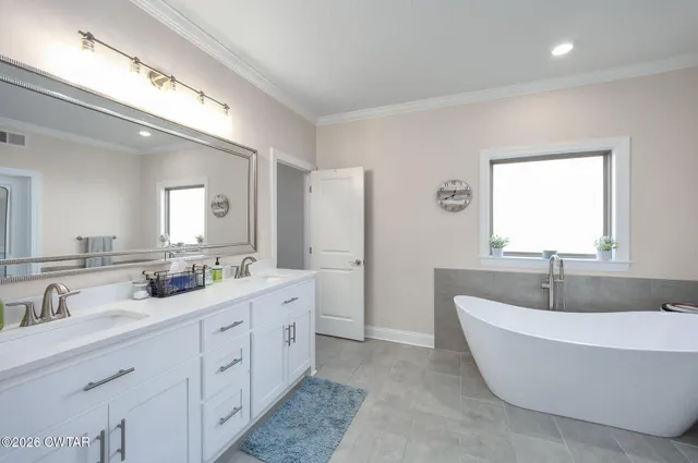 a spacious bathroom with a double vanity sink mirror and bathtub