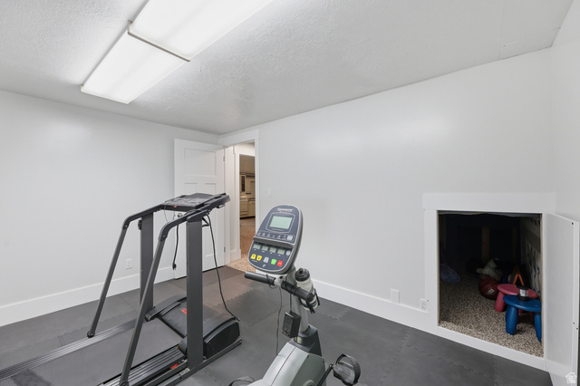 2342 Charros Road Sandy, UT 84092 - Photo 41 of 94 Versatile room with white walls and a large fluorescent light fixture