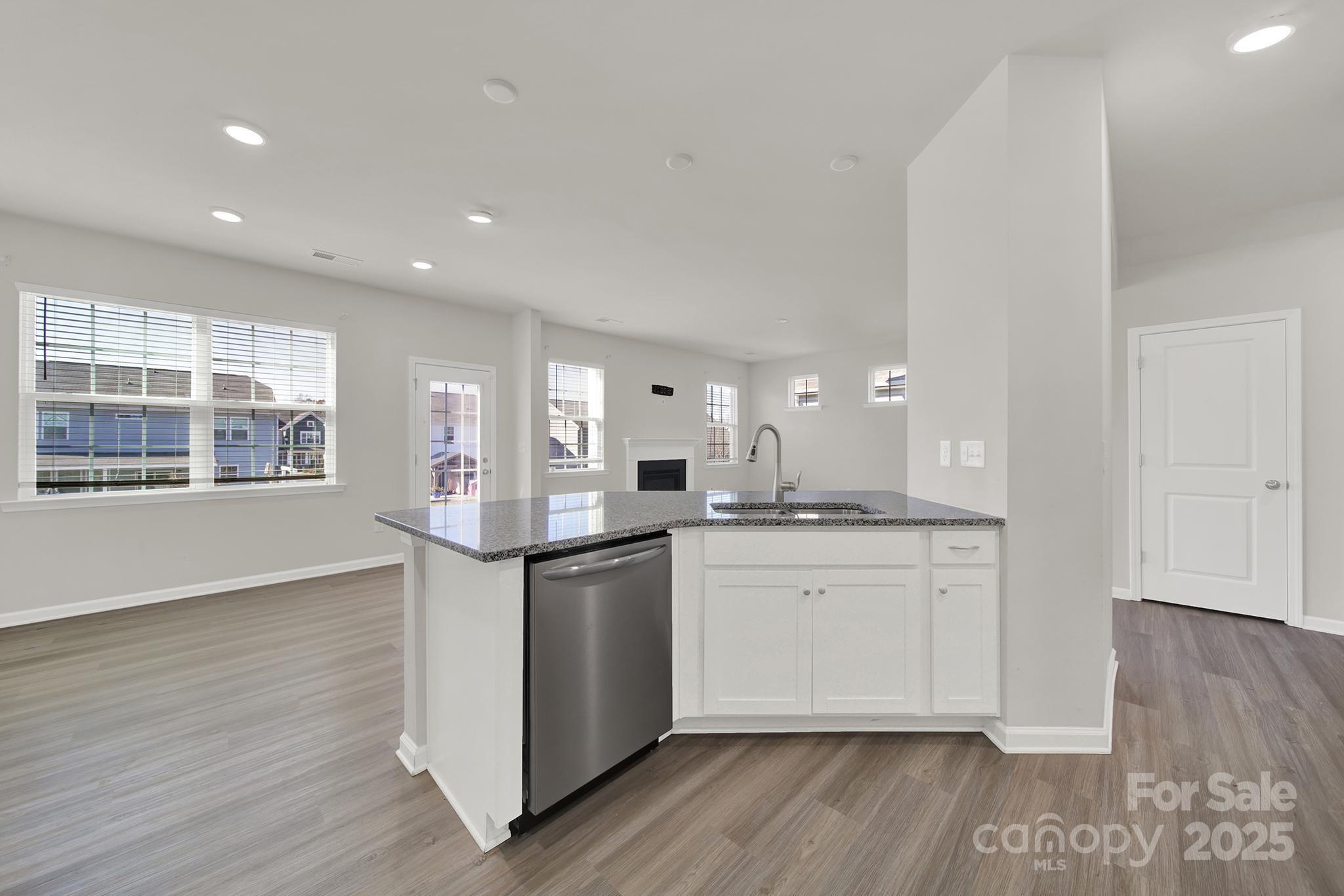 7721 Sea Turtle Way Lancaster, SC 29720 - Photo 14 of 46 a kitchen with stainless steel appliances granite countertop a sink cabinets and wooden floor