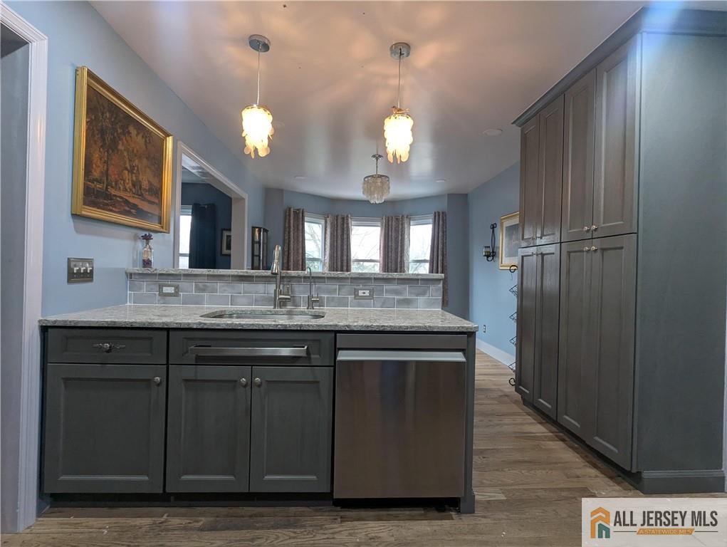 220 1st Street Dunellen, NJ 08812 - Photo 3 of 23 a bathroom with a granite countertop sink a light fixture and a mirror