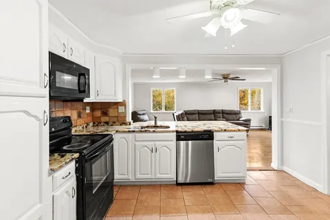 a kitchen with stainless steel appliances granite countertop a stove top oven a sink dishwasher and a refrigerator