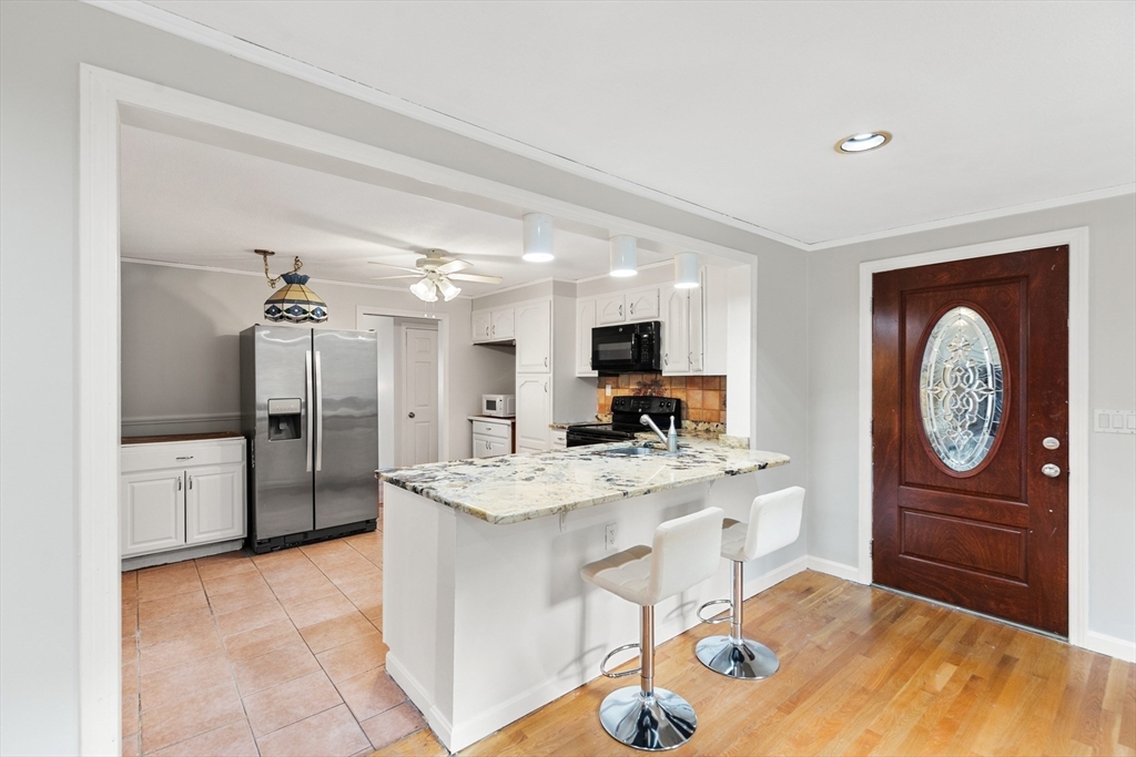 10 Apache Trail Medford, MA 02155 - Photo 12 of 41 a large kitchen with a refrigerator a stove a sink a dining table and chairs
