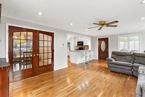 a living room with furniture and a flat screen tv with kitchen view