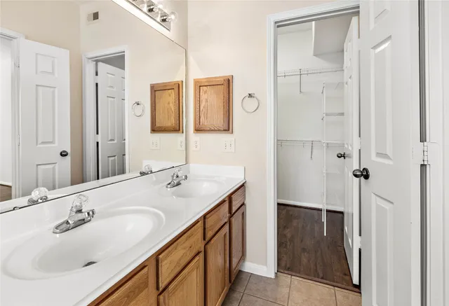 an empty room with wooden floor a ceiling fan and kitchen view