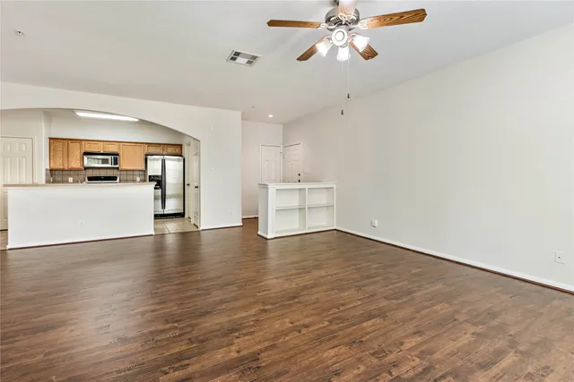 front view of a brick house with a yard and large trees
