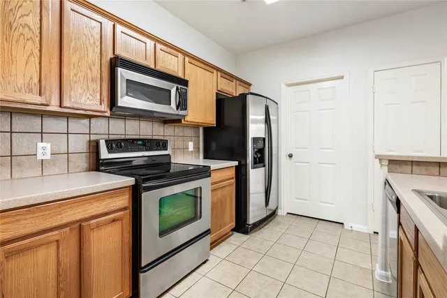 a kitchen with stainless steel appliances granite countertop a stove a refrigerator and a microwave