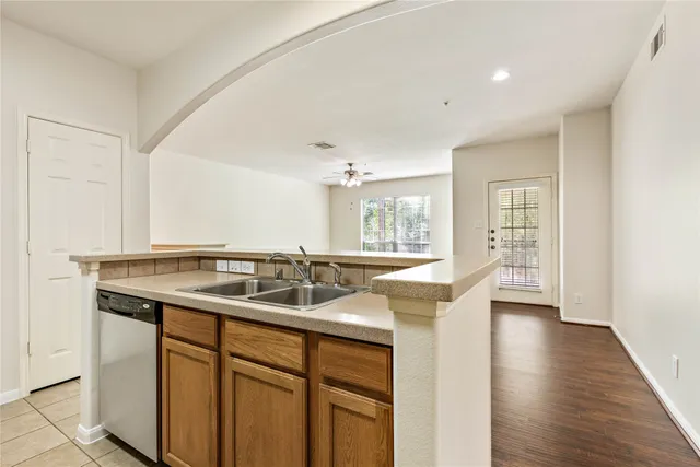 a kitchen with a sink and a stove top oven with wooden floor