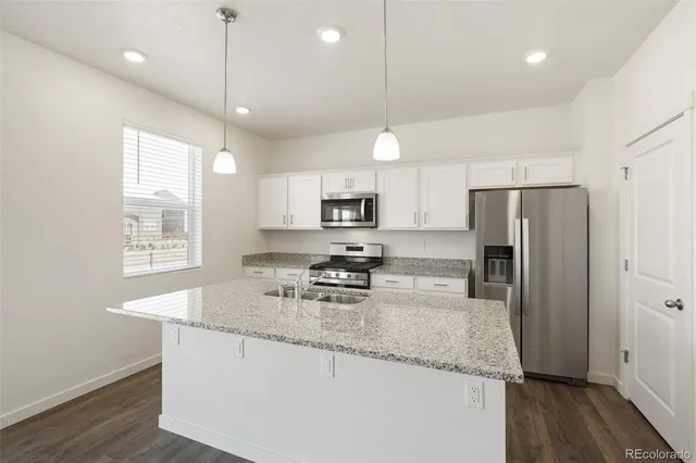 a kitchen with stainless steel appliances granite countertop a sink refrigerator and microwave