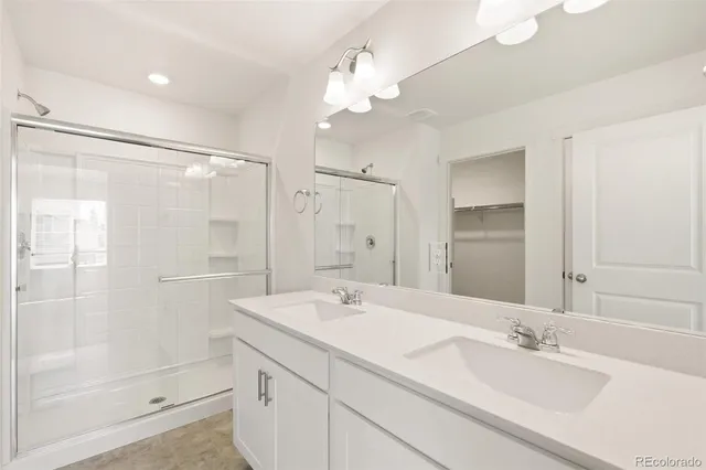a bathroom with a double vanity sink mirror and shower