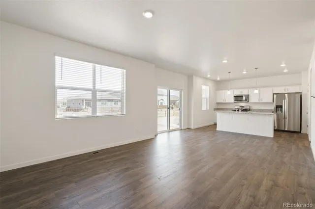 a view of a kitchen with a sink wooden cabinets and a window