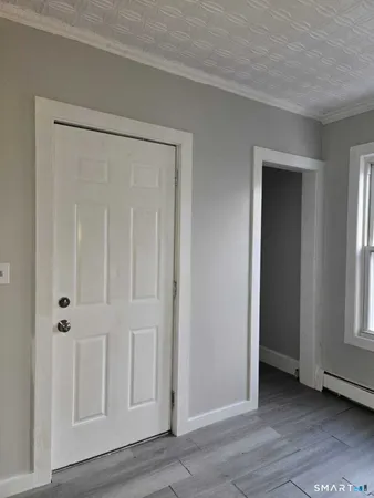 a view of empty room with wooden floor