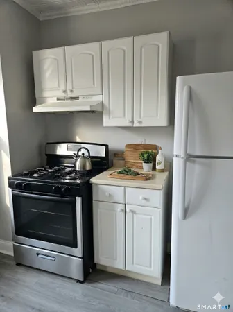a kitchen with granite countertop white cabinets and stainless steel appliances