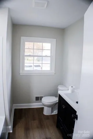 a bathroom with a sink toilet and a window