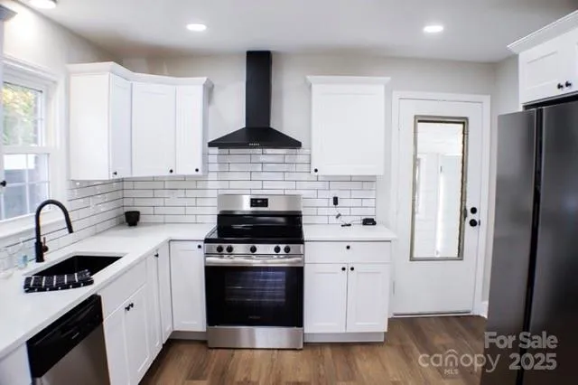a kitchen with stainless steel appliances a stove sink and refrigerator
