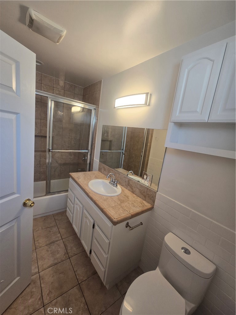 4428 Stansbury Avenue Sherman Oaks, CA 91423 - Photo 7 of 8 a bathroom with a granite countertop sink a toilet and mirror