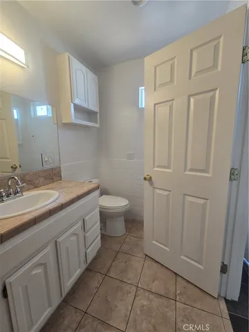 a bathroom with a granite countertop sink and a toilet
