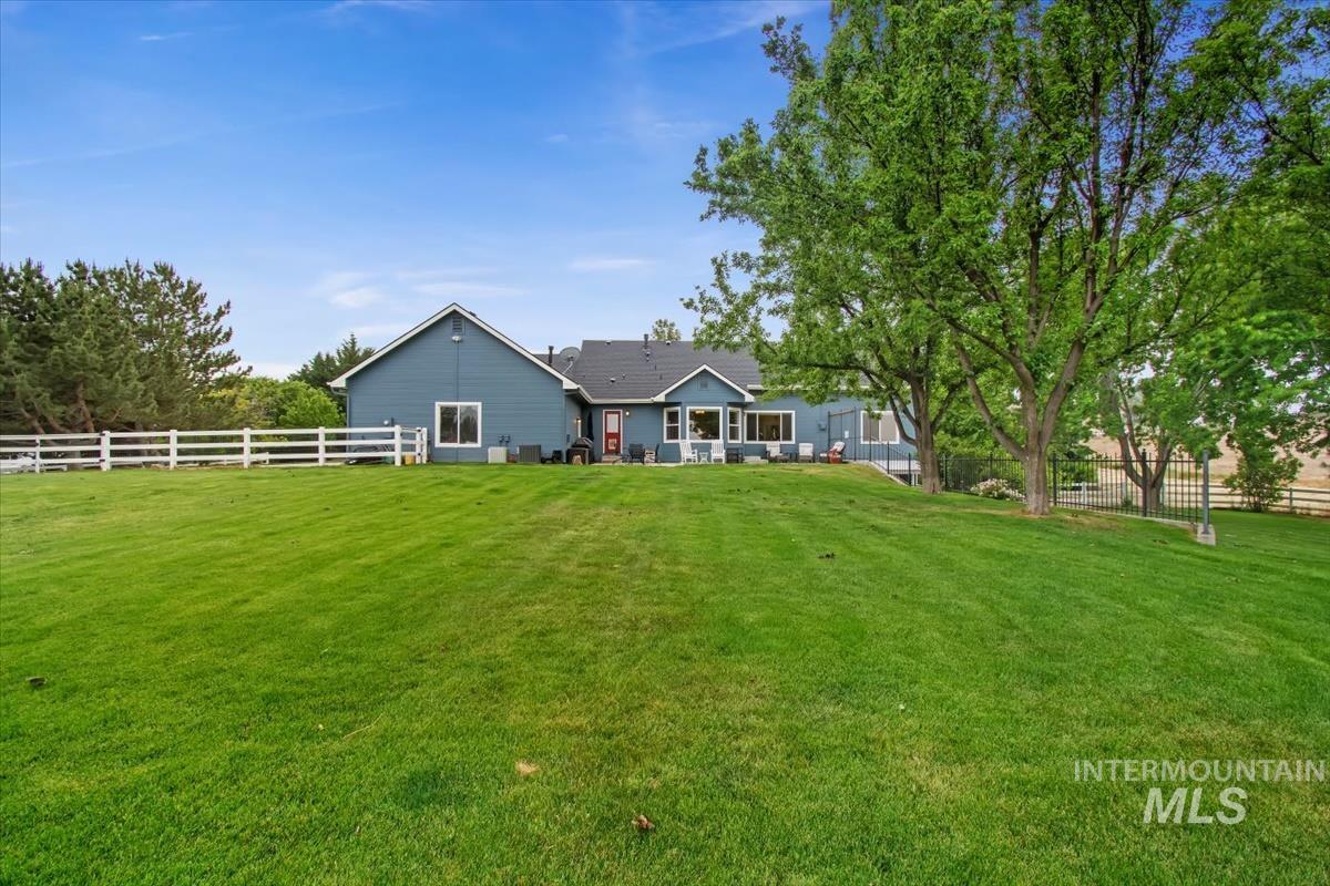 10462 West Lanktree Gulch Road Star, ID 83669 - Photo 43 of 48 Expansive green lawn with a white rail fence bordering the property