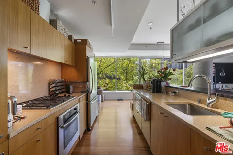 a kitchen with stainless steel appliances granite countertop a stove a sink and a refrigerator