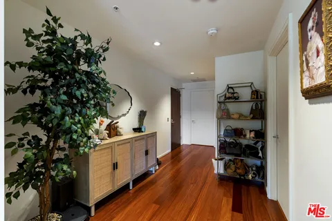 a hallway with a dining table chairs and wooden floor
