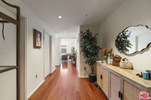 a living room with stainless steel appliances furniture large window and wooden floor