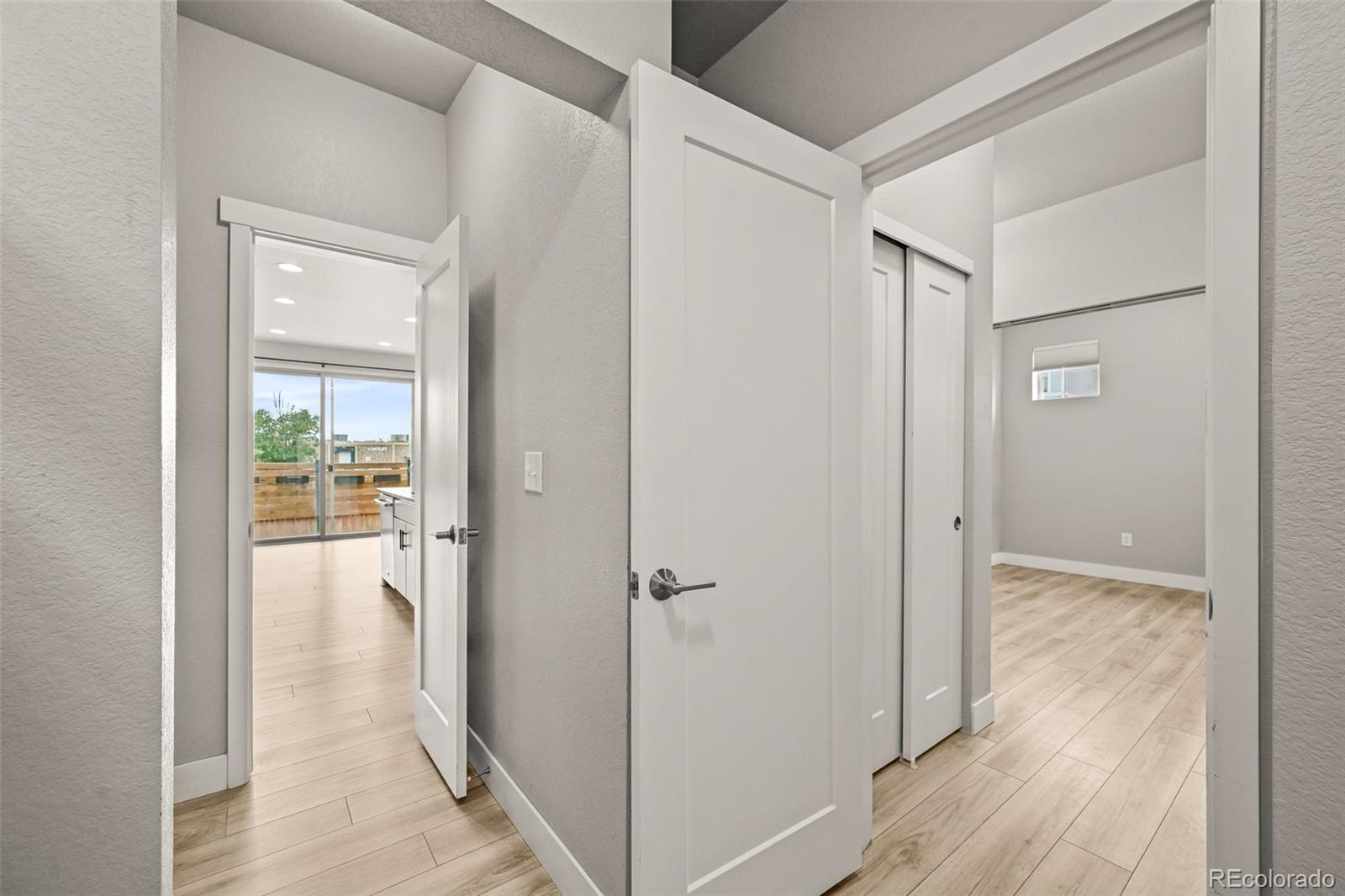 2880 West 69th Avenue Denver, CO 80221 - Photo 12 of 45 a view of a hallway with wooden floor and a bathroom