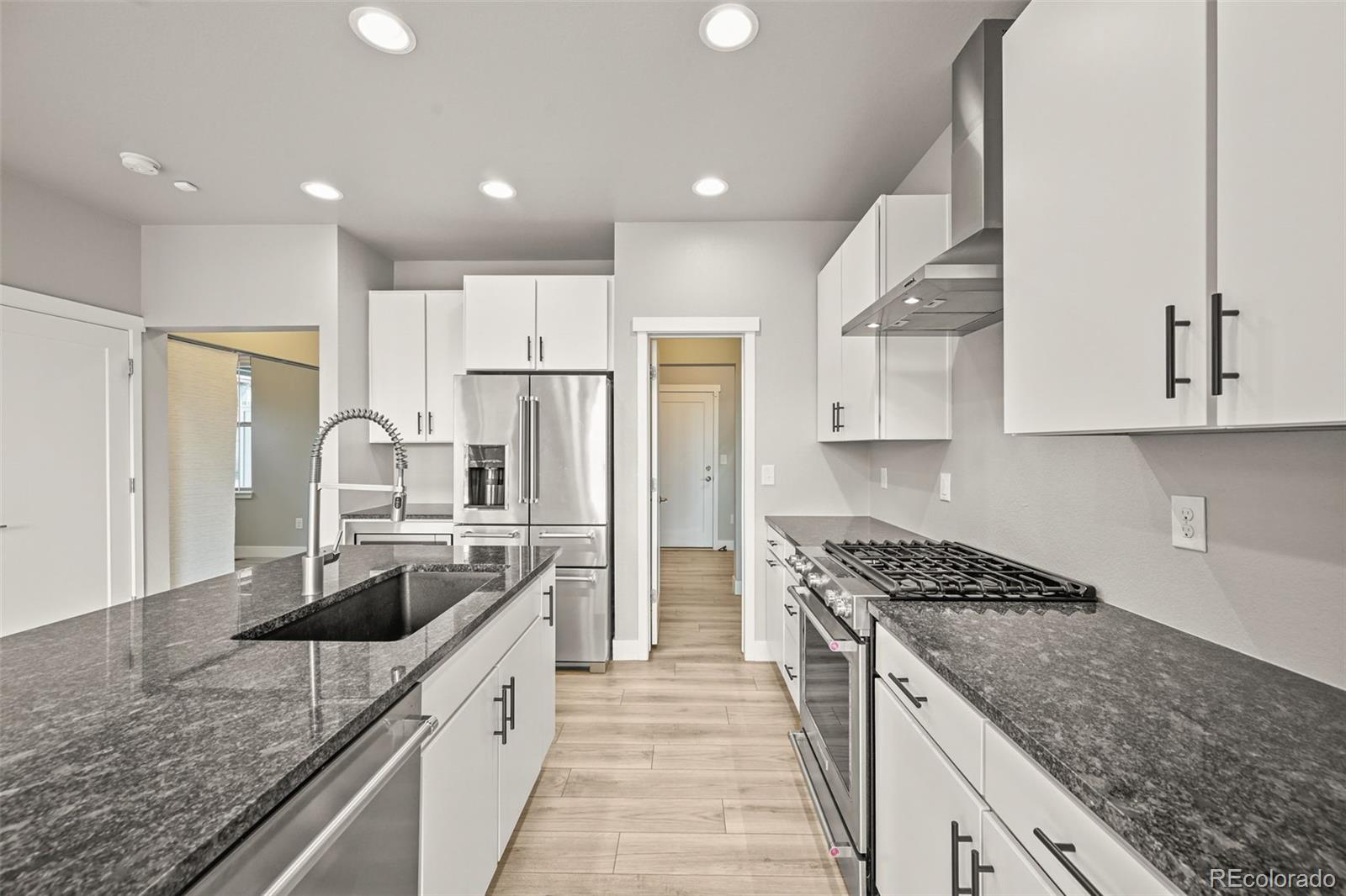 2880 West 69th Avenue Denver, CO 80221 - Photo 20 of 45 a kitchen with stainless steel appliances granite countertop a sink stove and refrigerator