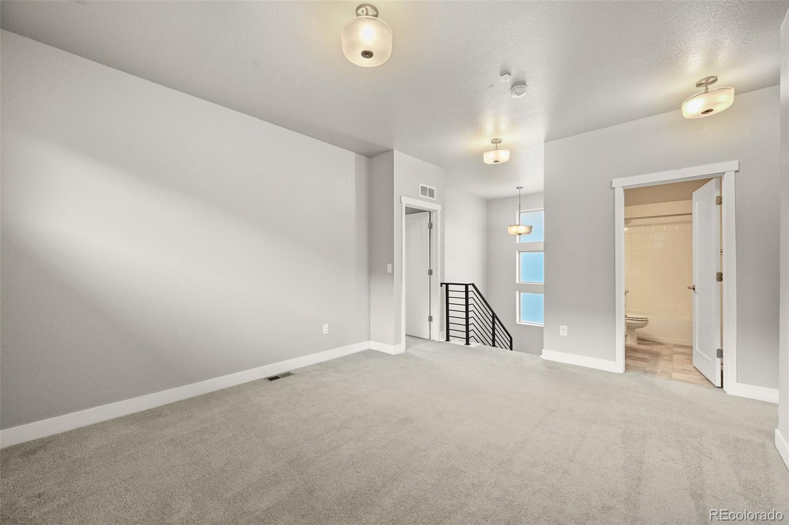 2880 West 69th Avenue Denver, CO 80221 - Photo 25 of 45 an empty room with a ceiling fan and bathroom view