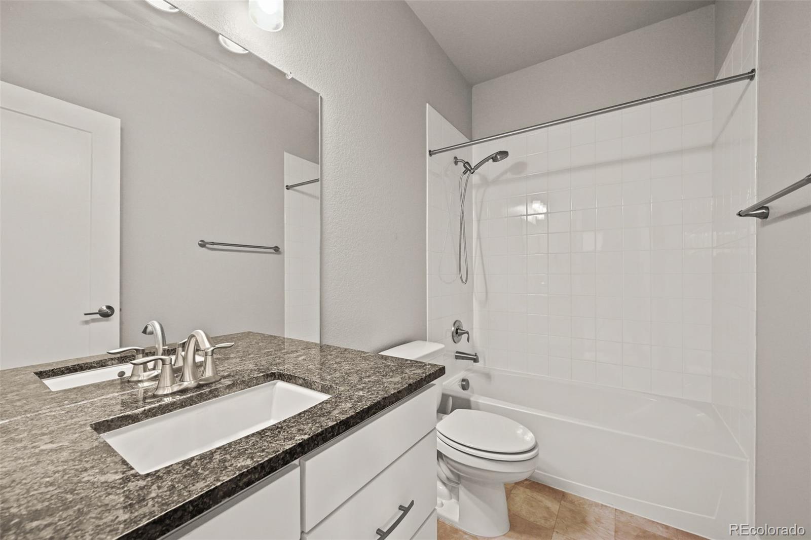 2880 West 69th Avenue Denver, CO 80221 - Photo 30 of 45 a bathroom with a granite countertop sink toilet and shower