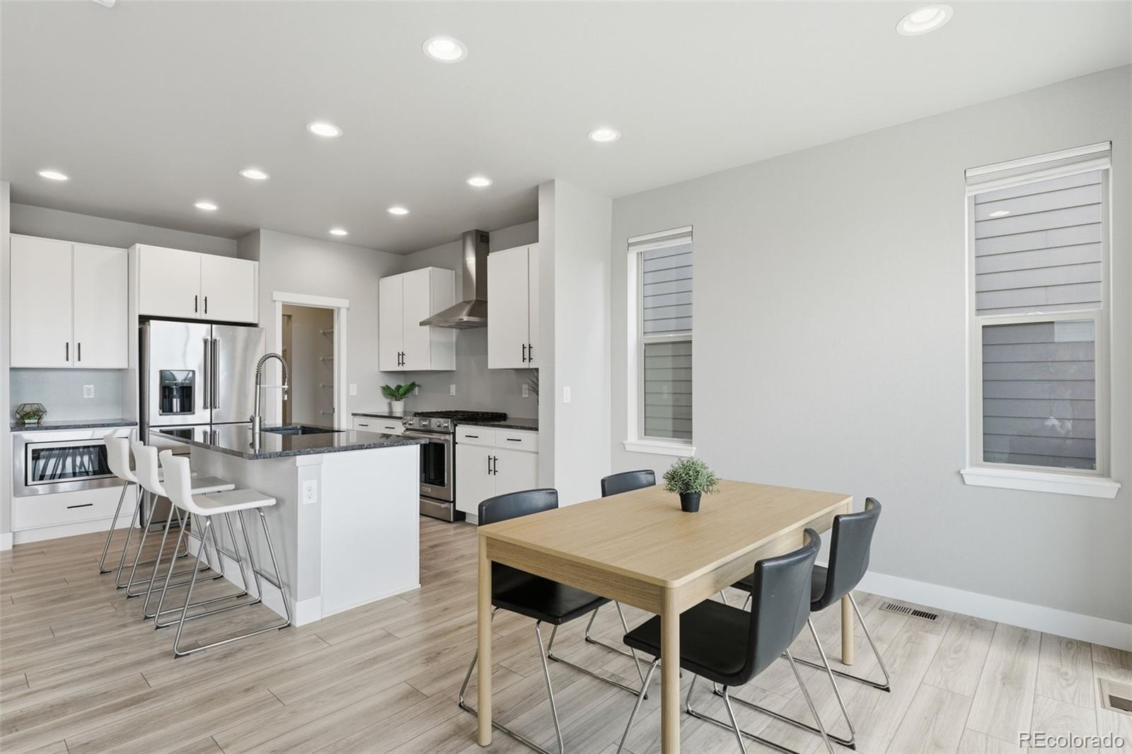 2880 West 69th Avenue Denver, CO 80221 - Photo 6 of 45 a kitchen with stainless steel appliances kitchen island granite countertop a kitchen island hardwood floor and a stove top oven