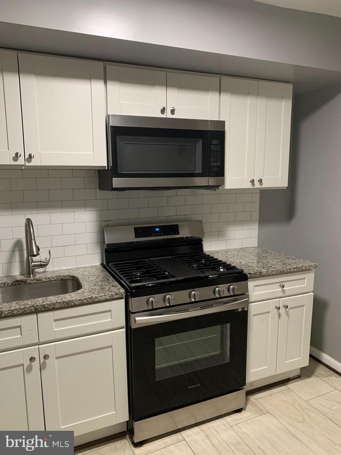 2708 Mathews Street Baltimore, MD 21218 - Photo 7 of 20 a kitchen with stainless steel appliances granite countertop a stove and a microwave