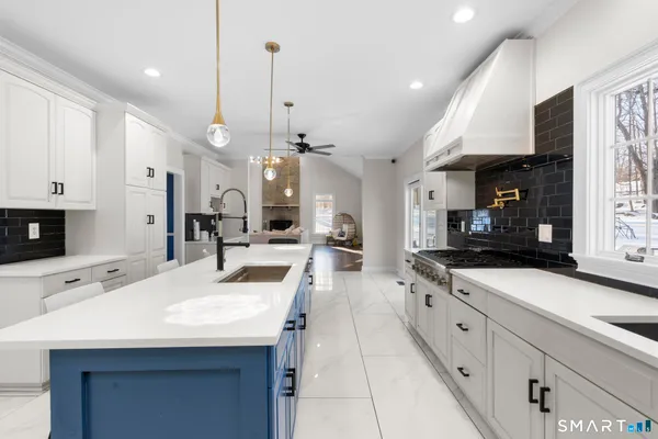 a large kitchen with kitchen island a sink stainless steel appliances and cabinets
