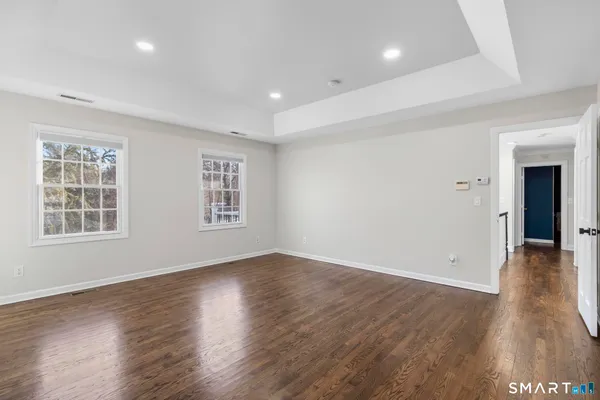 a view of an empty room with window and wooden floor