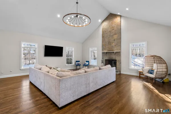 a living room with furniture wooden floor and a flat screen tv
