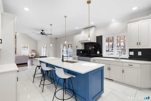 a large kitchen with kitchen island a sink table and chairs
