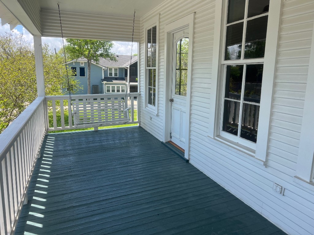 618 Bayridge Road La Porte, TX 77571 - Photo 5 of 50 Charming front balcony with a classic swing, perfect for savoring peaceful neighborhood views.