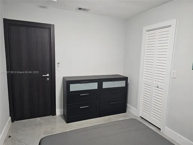 a bedroom with a bed and a cabinet