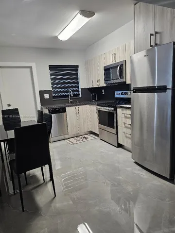 a kitchen with stainless steel appliances white cabinets and a refrigerator