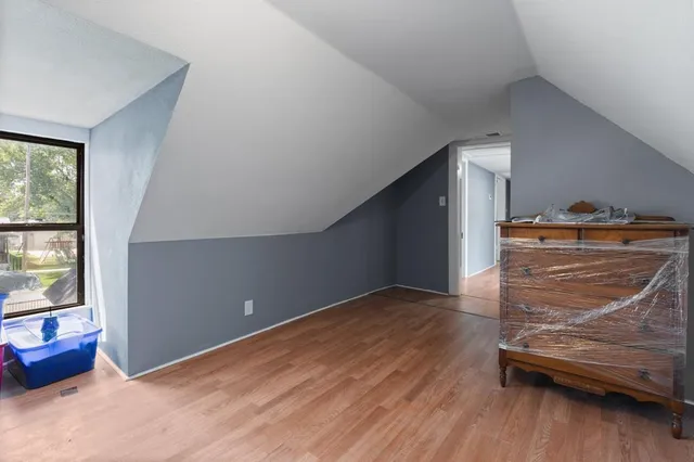a view of a livingroom with wooden floor and furniture