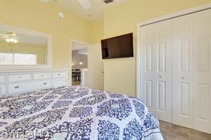1670 Windy Pines Drive, Unit 2510 Naples, FL 34112 - Photo 5 of 9 a bedroom with a large bed and a flat screen tv