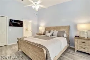 a bedroom with a bed a flat screen tv and a chandelier