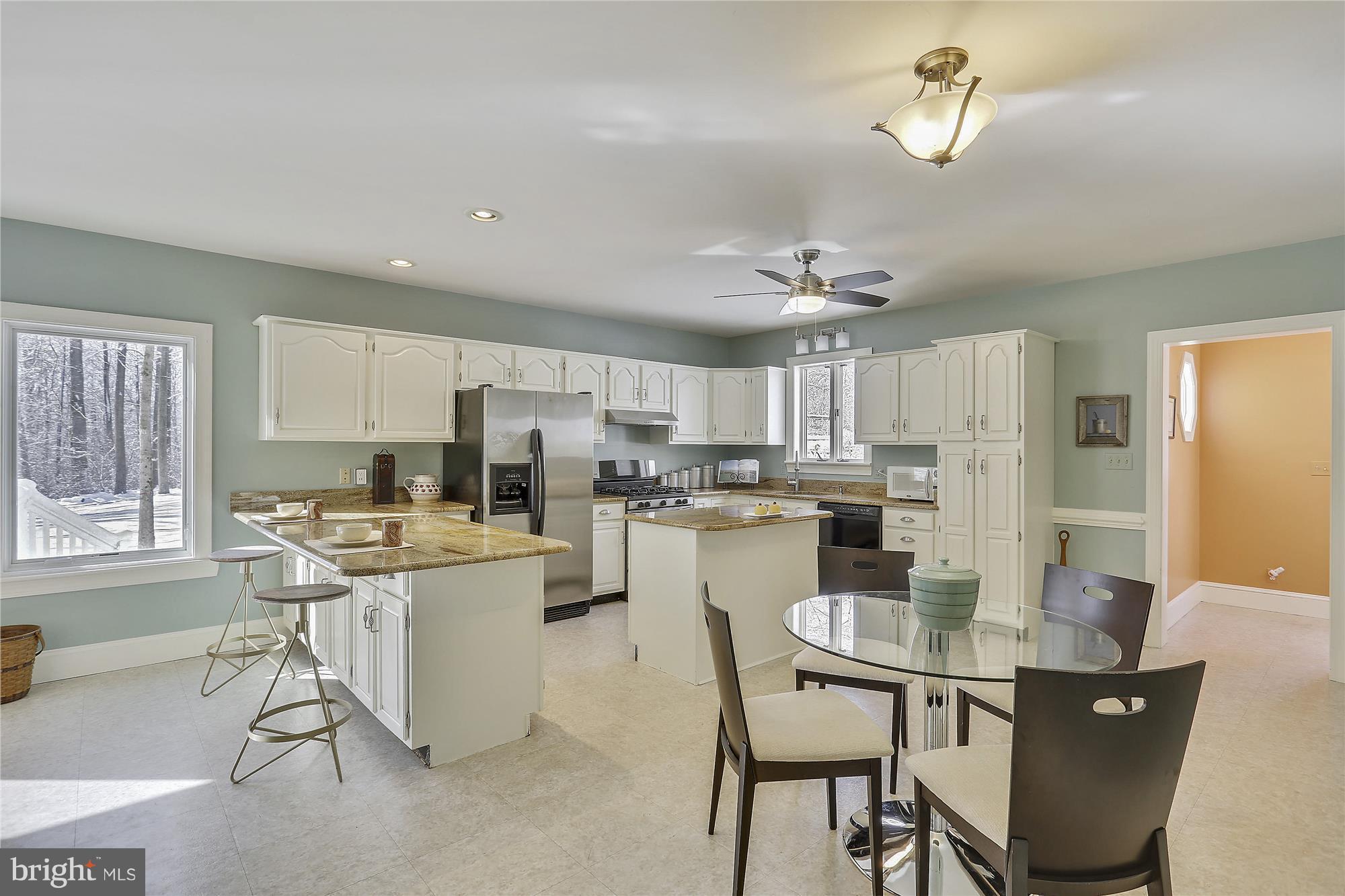 1711 Ashton Road Ashton, MD 20861 - Photo 5 of 30 a kitchen with a dining table chairs and refrigerator