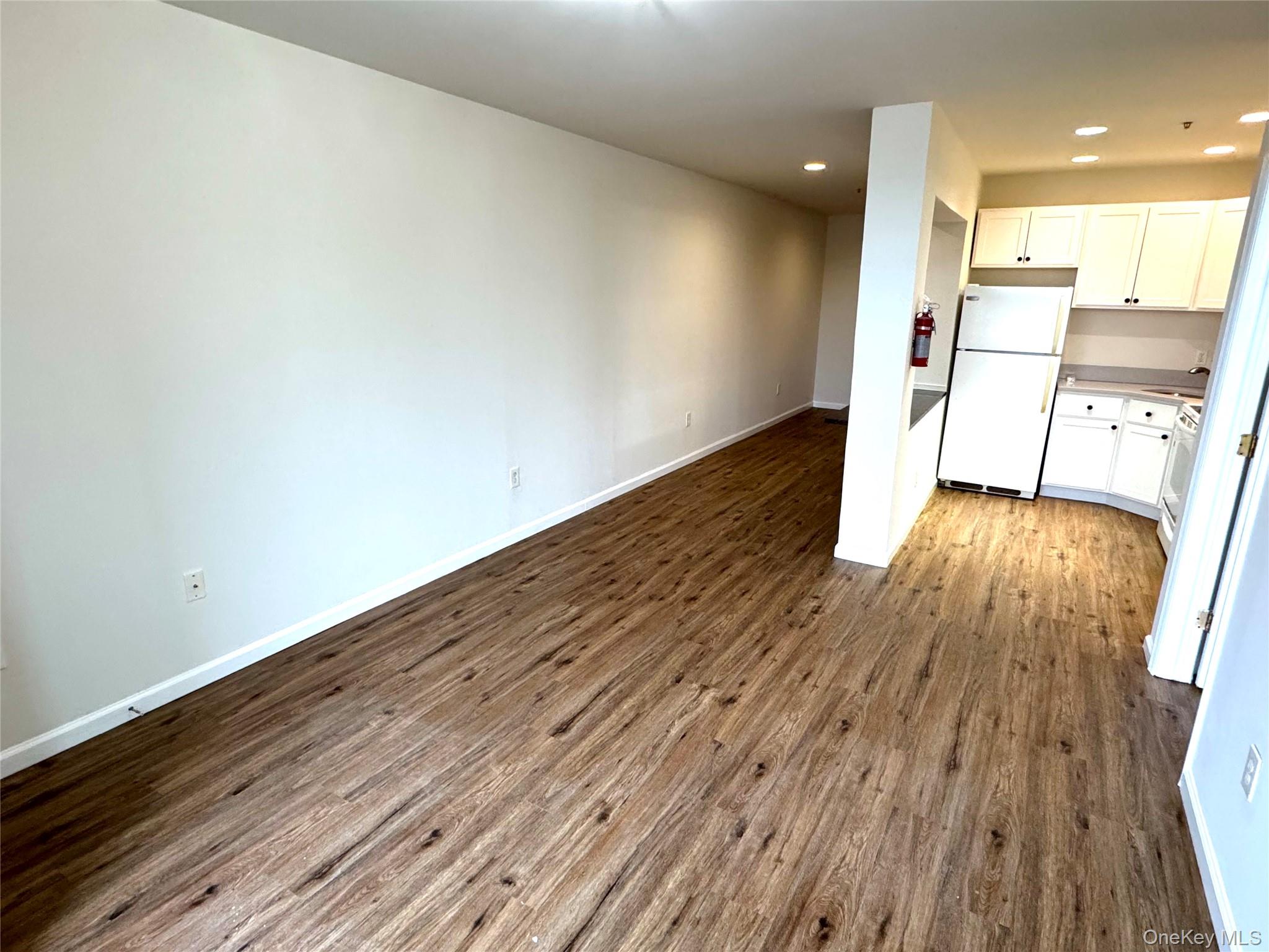 315 Main Street, Unit 3 Poughkeepsie, NY 12601 - Photo 4 of 13 an empty room with wooden floor and entrance