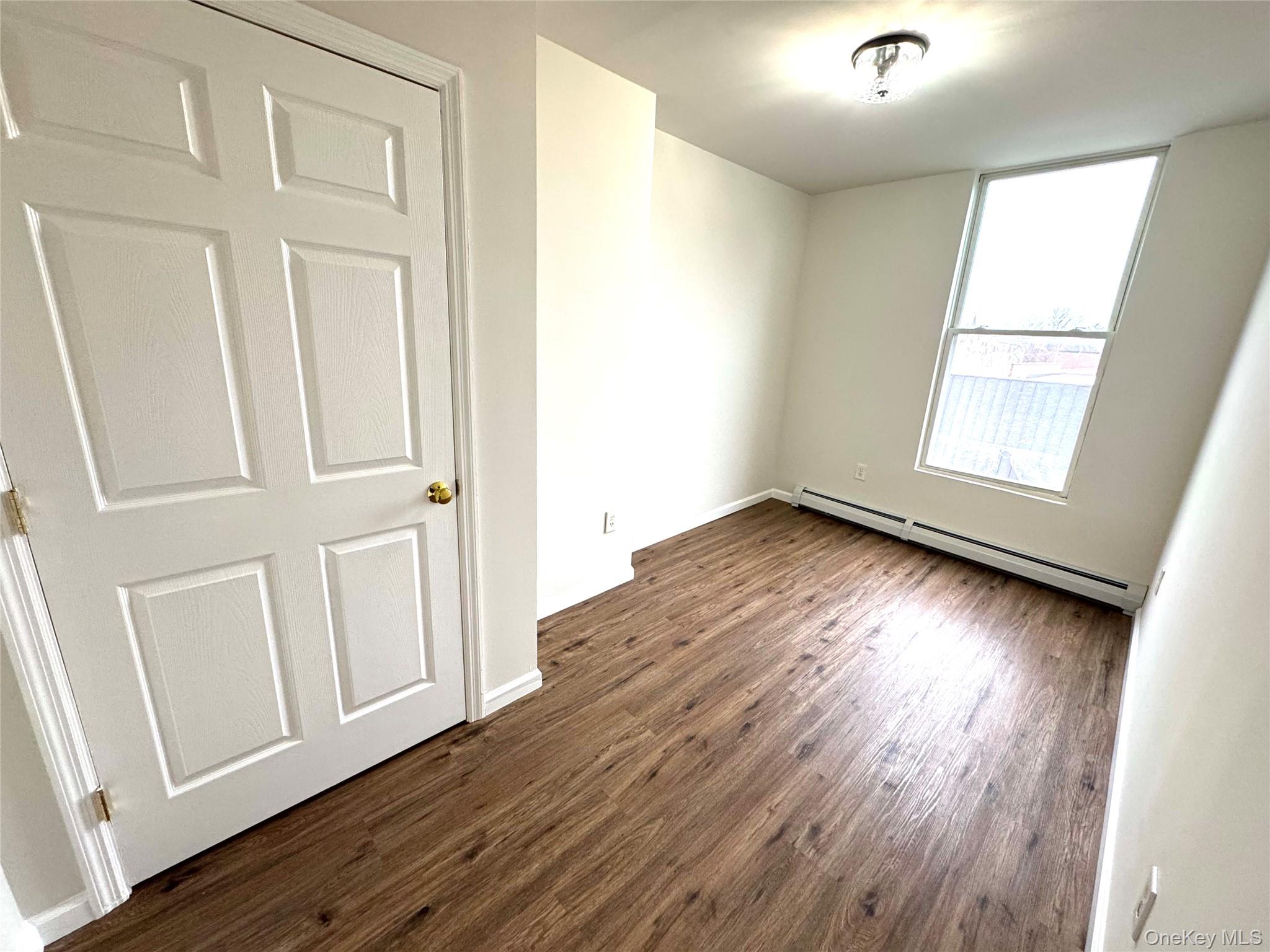 315 Main Street, Unit 3 Poughkeepsie, NY 12601 - Photo 10 of 13 an empty room with wooden floor and windows