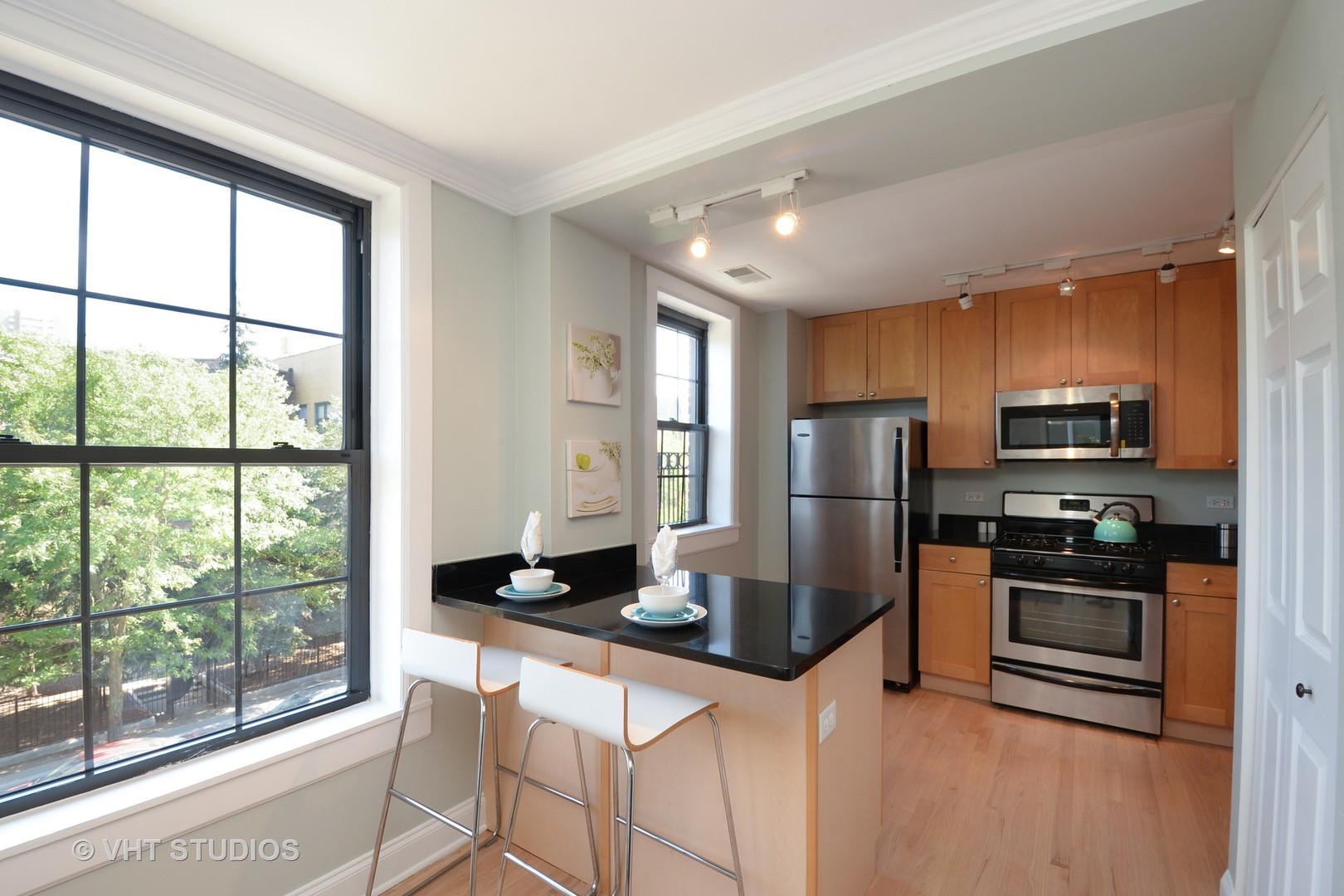 4144 North Sheridan Road, Unit 311 Chicago, IL 60613 - Photo 3 of 10 a kitchen with stainless steel appliances granite countertop a refrigerator a stove top oven a sink and dishwasher