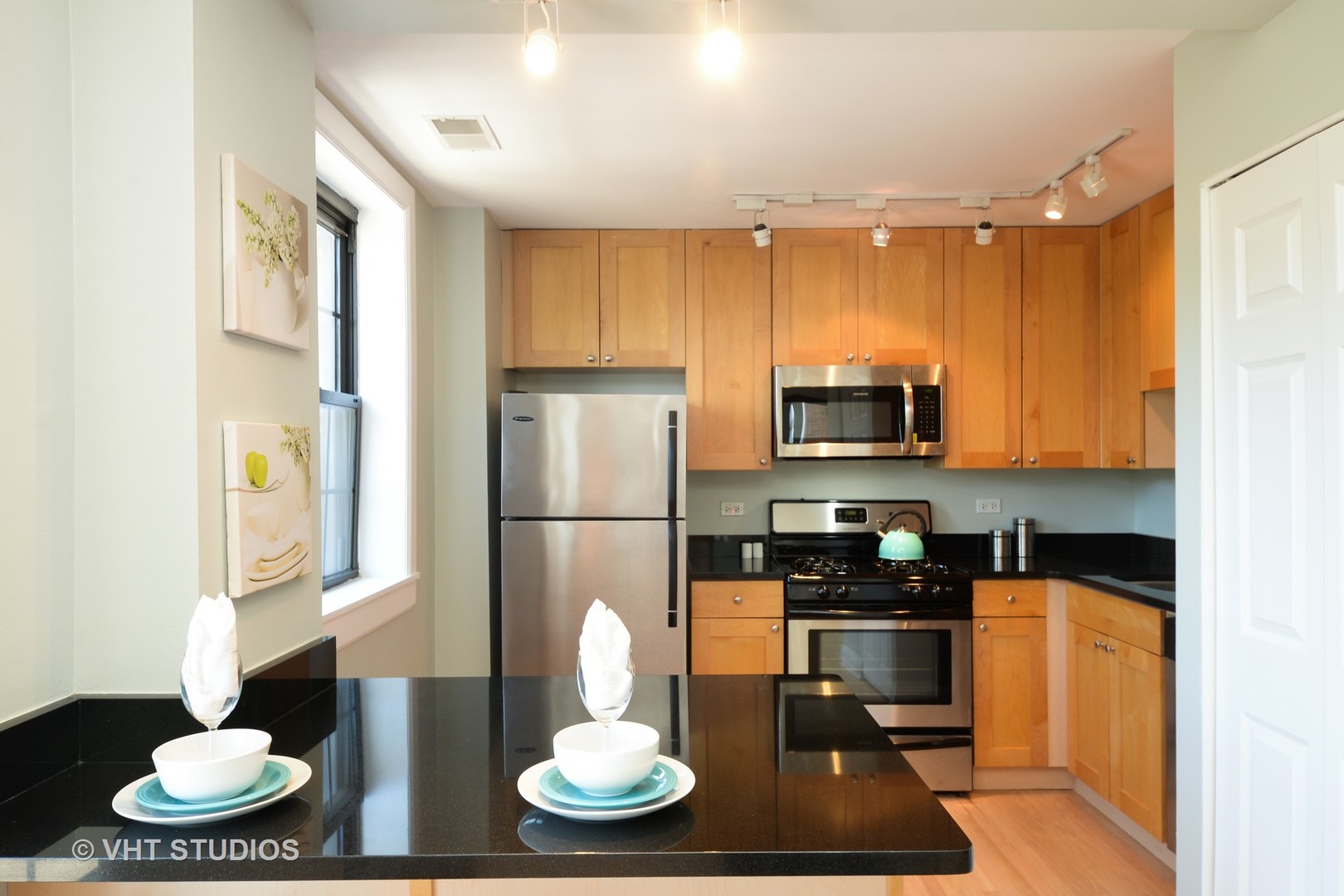 4144 North Sheridan Road, Unit 311 Chicago, IL 60613 - Photo 4 of 10 a kitchen with a refrigerator and a wooden floor